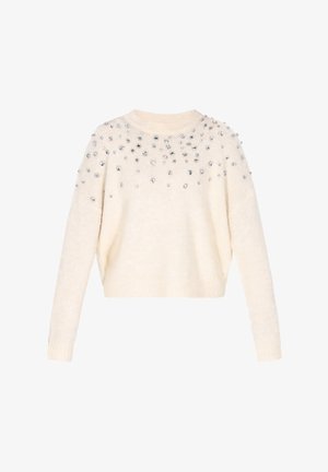 Kremowy sweter wykonany z miękkiego materiału, o luźnym kroju, zaokrąglonym dekolcie i zdobiony srebrnymi cyrkoniami na ramionach.