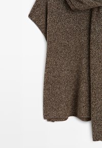 Tissu tricoté texturé marron et beige avec un motif tissé doux et un ourlet lâche et drapé.