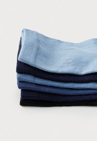 Set di quattro paia di calzini piegati in diverse tonalità di blu e nero. Realizzati in un tessuto a maglia liscia con polsini a coste.