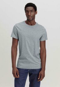 Grijze katoenen t-shirt met een ronde hals en korte mouwen, aansluitend ontwerp, gladde textuur, gecombineerd met donkerblauwe jeans.