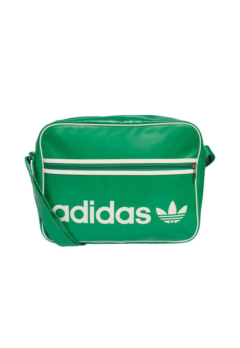 Grønn syntetisk crossover-veske med hvit "adidas"-logo, glidelåslomme foran og kontrastfarget hvit piping. Justerbar skulderreim.
