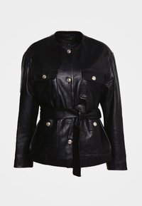 Schwarze Lederjacke mit Mandarin-Kragen, zwei Vorderaschen und einem gebundenen Taillengürtel. Glänzende silberne Knöpfe akzentuieren die Taschen.