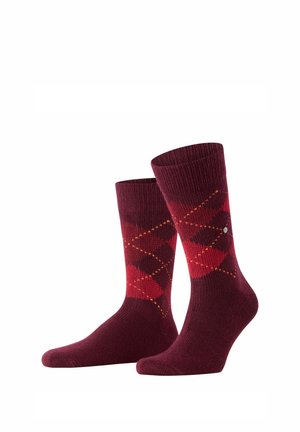 Par de calcetines burgundy hasta media pantorrilla con patrón de rombos en rojo y rojo oscuro y pequeñas líneas punteadas naranjas sobre fondo blanco.