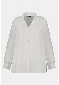 Camicia bianca in lino con maniche lunghe, chiusura con bottoni sul davanti e collo a V. Presenta spacchi laterali e una vestibilità rilassata. Tessuto morbido.