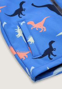 Blauer Stoff mit verschiedenen Dinosaurier-Silhouetten in Schwarz, Pink und Creme. Glatte Textur mit einem Reißverschluss und einer Seitenauftasche.