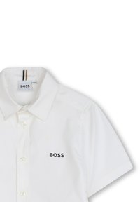 Witte short-sleeve shirt van gladde stof, met een klassieke kraag en een klein zwart "BOSS" logo op de linkerborst.