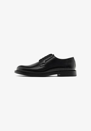 Schwarzer Herrenschuh im Oxford-Stil aus Leder mit geschlossener Schnürung, abgerundetem Zehenbereich und niedrigem gestapeltem Absatz auf weißem Hintergrund.