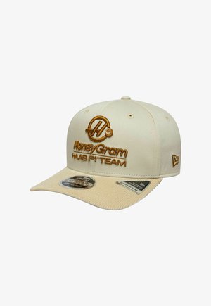 Beige Baseballkappe mit braunen MoneyGram- und Haas F1 Team-Logos auf der Vorderseite sowie dem New Era-Logo an der Seite gestickt.