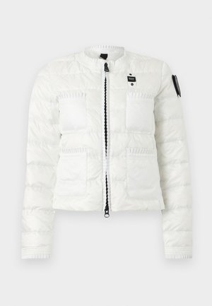 White quilted jacket with front zipper, two upper chest pockets, two lower pockets, and a black patch on the left sleeve.