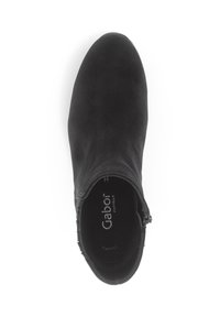 Botte de cheville en daim noir avec un bout arrondi et une fermeture éclair sur le côté. L'intérieur comporte un logo et une semelle intérieure texturée pour le confort.