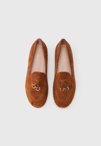 Brown suede loafers with a rounded toe, featuring a decorative tie and metallic accents in gold, silver, and bronze. Smooth inner lining.