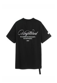 Camiseta negra de manga corta con texto en cursiva blanco en la parte posterior: "Sin ataduras" con "SIN GÉNERO SIN MALOS HÁBITOS SIN RESTRICCIONES" debajo.