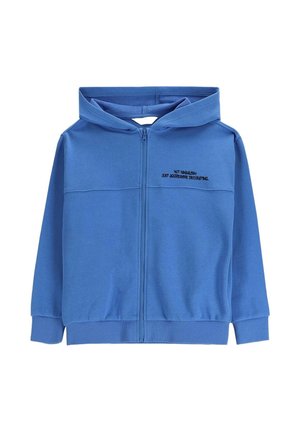 Niebieska bluza z kapturem zapinana na zamek, z przednimi kieszeniami i czarnym napisem na lewej piersi: „TO NIE WANDALIZM, TYLKO AGRESYWNE DEKOROWANIE.”