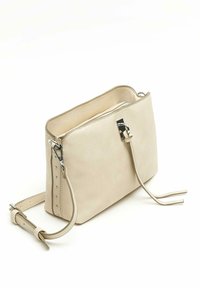 Bežna torbica z teksturo, z zapiranjem na zadrgo, srebrnim okovjem in dolgo nastavljivo naramnico. Ima stranske poudarke z majhnimi žebljički.