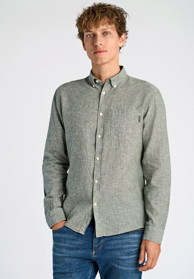 Camicia verde chiaro, con bottoni, a maniche lunghe, vestibilità casual, con una tasca sul petto, in tessuto texturizzato, indossata con jeans blu.