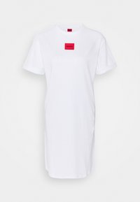 Biała bawełniana sukienka T-shirt z okrągłym dekoltem, krótkimi rękawami oraz czerwoną naszywką w kształcie kwadratu z logo "HUGO" umieszczonym na środku klatki piersiowej.
