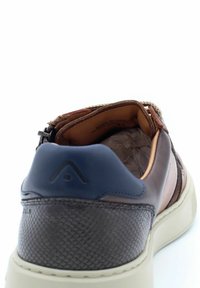 Sneaker in pelle marrone con un pannello texturizzato di colore marrone scuro, dettagli in marrone chiaro e un tassello blu sul tallone; presenta una chiusura a zip sul lato.