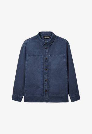 Chemise bleue foncée à manches longues avec col et grandes poches plaquées sur le devant, présentée à plat sur un fond blanc.