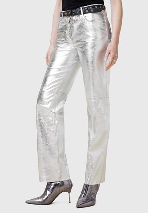 Pantalons métalliques argentés avec une coupe droite, dotés d'un zip et d'une ceinture noire avec des œillets dorés. Fini de surface texturé.