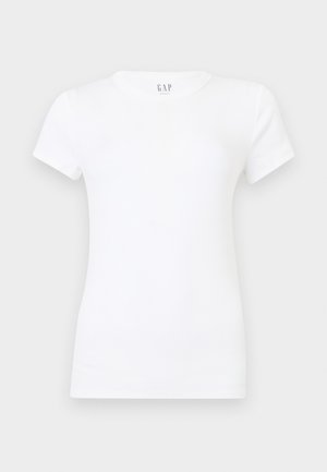 Απλό λευκό T-shirt με κοντά μανίκια και στρογγυλή λαιμόκοψη, με εφαρμοστή κοπή, εμφανίζεται σε ουδέτερο γκρι φόντο, με ετικέτα GAP στην εσωτερική πλευρά του γιακά.