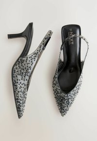 Schwarze Slingback-Highheels mit spitzer Zehenpartie, bedeckt mit schwarzen und silbernen dekorativen Perlen, mit glattem Lackleder-Finish und Absatz.
