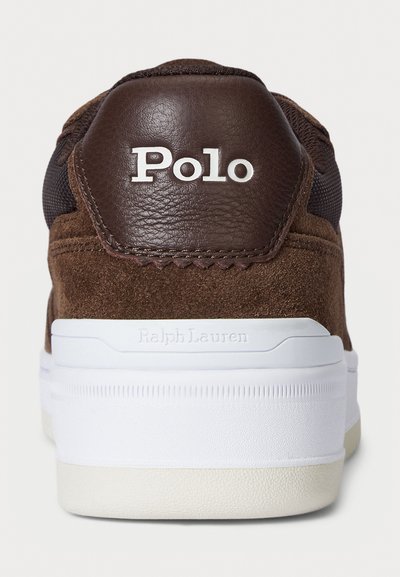 Adidași din suede și piele maro cu talpă din cauciuc alb. Prezintă logo-ul embosat "Polo" pe călcâi, accentuat de panouri texturate și cusături.