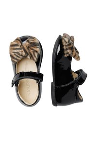 Scarpe di vernice nera con punta rotonda, una fascia in velcro e un fiocco in pelliccia sintetica marrone con motivo a righe sul davanti.