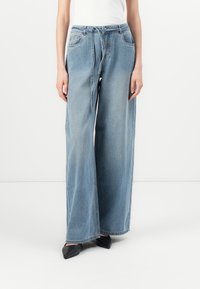 Ανοιχτό μπλε φαρδιά τζιν παντελόνια από τζιν ύφασμα, με ψηλή μέση, θήκες για ζώνη και μπροστινές τσέπες. Λεπτή υφή και χωρίς ορατά σχέδια.