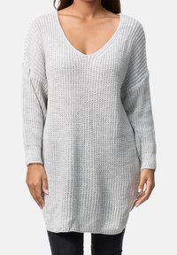 Jasnoszary sweter dziergany z głębokim dekoltem w kształcie litery V i długimi rękawami, o luźnym kroju i ściągaczach na mankietach. Delikatna faktura na całej powierzchni.