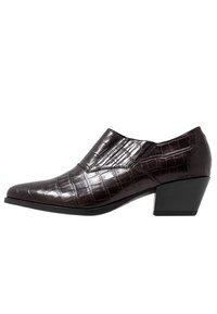 Mörkbrun klack sko med krokodilskinnsstruktur, med en spetsig tå och en låg, blockklack, placerad i profil.