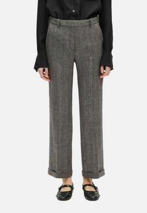 Pantalons rayés gris et noir avec une coupe droite, présentant un ourlet replié, des poches et une texture de tissu lisse.