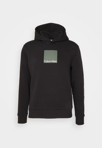 Zwarte hoodie met geribbelde manchetten en zoom, met een groen vierkant en het "Calvin Klein"-logo in het midden van de borst.