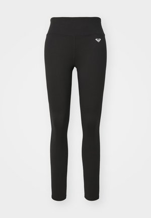 Leggings noirs avec une taille haute, fabriqués dans un matériau extensible. Présente un petit logo sur la hanche et une texture lisse et mate.