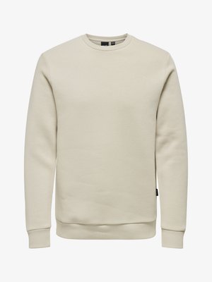 Bež dukserica s okruglim izrezom, dugim rukavima, rebrastim manžetama i rubom, izrađena od mekog materijala, bez vidljivih logotipa ili uzoraka.