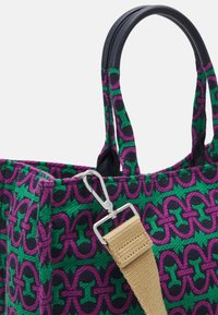 Torebka z plecionym wzorem w kolorze fioletowym i zielonym, z czarnymi akcentami, solidnymi podwójnymi uchwytami oraz odpinanym beżowym paskiem z srebrnym zapięciem.