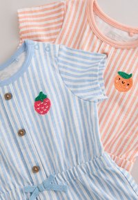 Två randiga babyoveraller, en blå med ett jordgubbs-patch och knappar, en rosa med ett apelsin-patch, båda kortärmade och i bomull.