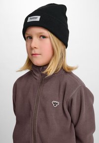 Fleecejacka i dämpad brun färg med dragkedja fram och broderad logotyp. Svart stickad mössa. Slät textur, avslappnad design och varm look.