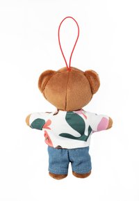 Plyšový klíčenka ve tvaru medvídka z hnědé látky, oblečený v květované košili a džínových šortkách. Na vrchu je červená závěsná smyčka.