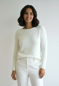 Biały, teksturowany sweter z okrągłym dekoltem i długimi rękawami, zestawiony z dopasowanymi białymi spodniami. Gładka tkanina i minimalistyczny design.