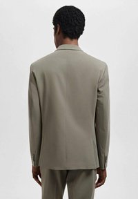 Light grey blazer viewed from the back. Features notched lapels, tailored fit, and smooth fabric. Buttoned cuffs visible on sleeves.