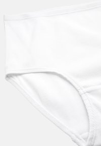 Vit ribbad bomullstrumpa med hög midja, med en slät yta och sömmar för hållbarhet och komfort.