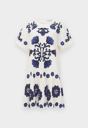 Vestido blanco con mangas cortas, que presenta bordados florales azules y una falda de volantes. Detalles notables incluyen flores en azul oscuro y un dobladillo con forma de onda.