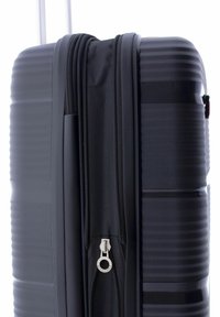 Valigia rigida nera con texture scanalata, due scomparti con zip e una superficie liscia, dotata di una zip argentata.
