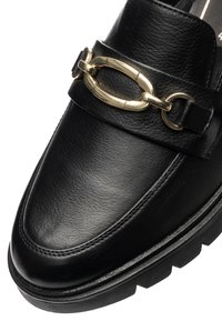 Black leather loafers with a rounded toe, featuring a gold chain accent and rubber traction sole. Stitch detailing along the edges.