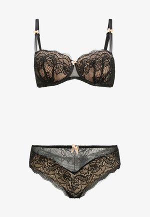 Senza spalline nera in pizzo e completino coordinato presentano motivi floreali, dettagli in rete trasparente e piccoli fiocchi rosa. Texture morbide con colori a contrasto.