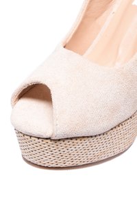 Scarpa platform in suede beige con punta aperta, texture intrecciata sul plateau e finitura liscia sulla parte superiore, con una forma frontale arrotondata.