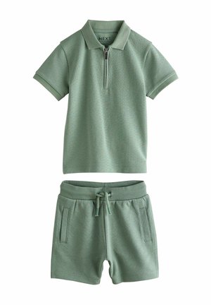 Polo scurt cu mânecă scurtă de culoare verde mentă, cu guler cu fermoar și pantaloni scurți asortați. Ambele au un material texturat și o talie elastică cu șnur.