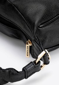 Czarna torebka skórzana o teksturowanej powierzchni z złotym suwakiem. Posiada pleciony pasek i metalowe akcenty. Kompaktowy design z wyrafinowanym wykończeniem.