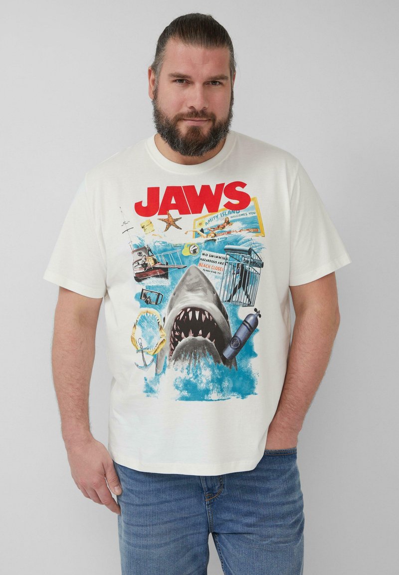 Weißes Baumwoll-T-Shirt mit einem großen Grafikdruck eines Hais, Wellen und nautischen Elementen, mit dem fett gedruckten Text "JAWS" in kräftigem Rot.