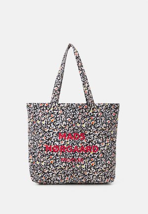 Tragetasche mit abstraktem Muster in Schwarz, Weiß, Gelb und Orange, zwei Griffen und rotem Text "MADS NØRGAARD RECYCLED" auf der Vorderseite.